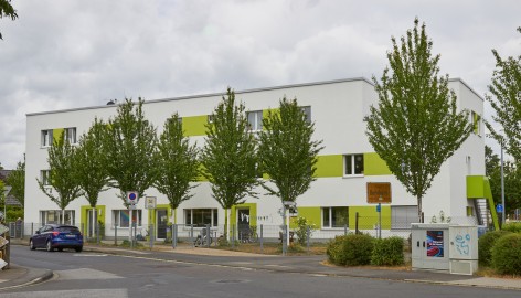 Mehrfamilenhaus mit weiß-grüner Fassade und 3 Etagen
